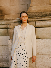 a lady in a white worsted wool one button blazer
